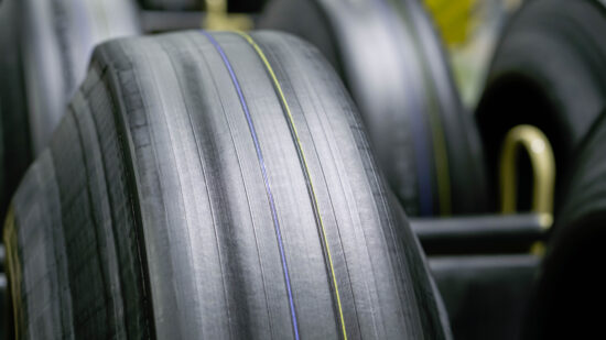 Tyre manufacturing production in factory warehouse, Green tire radial, extruded rubber layers preparing to mold for the curing process, car logistic transportation industry