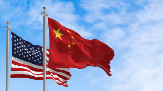 National flags of China and the United States waving in the wind on a clear day